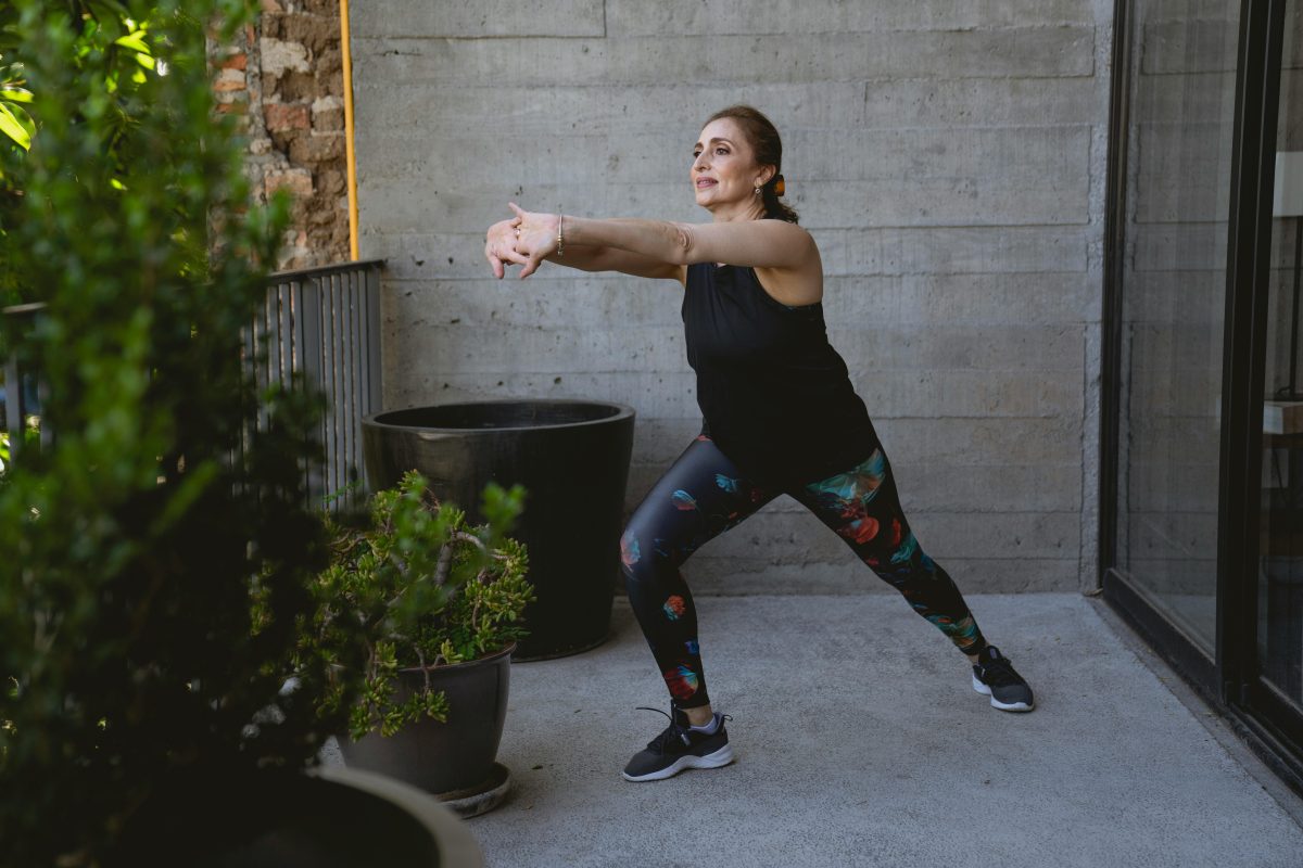 Elderly Woman in Gray Tank Top and Leggings Exercising