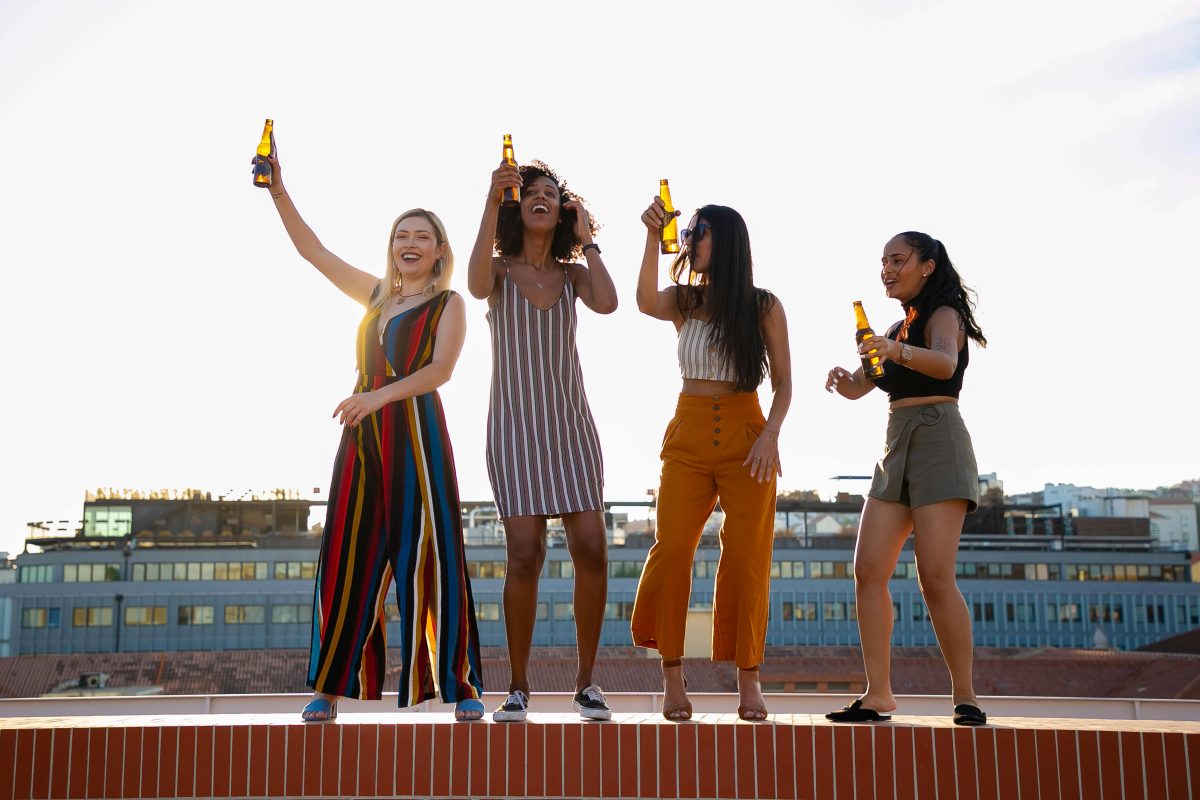 Positive young diverse guys dancing on building roof during party