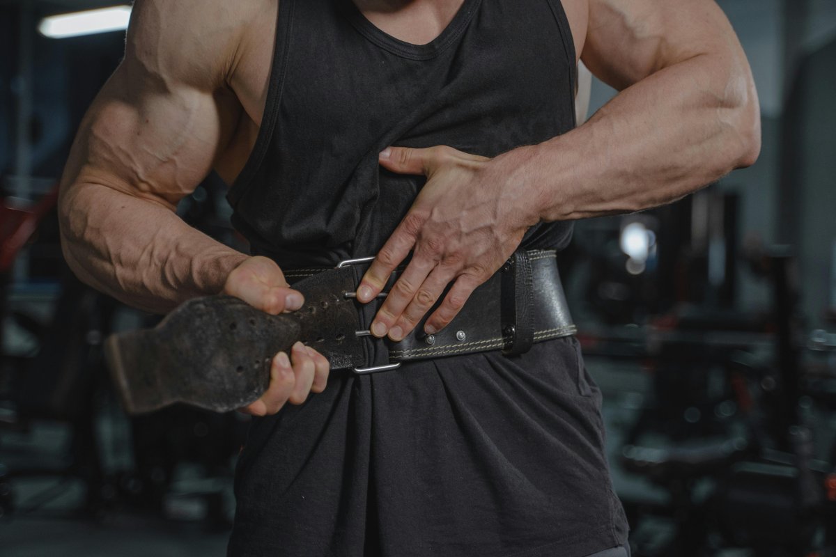 Man in Black Tank Top Putting Weightlifting Belt